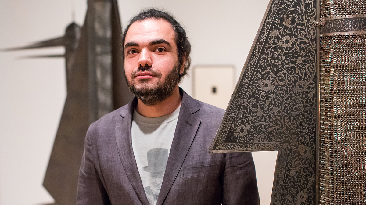 Shapour Pouyan stands amid his hanging sculpture installation in a gallery.